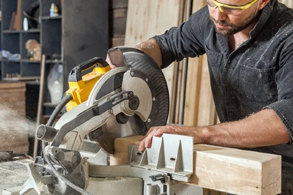 Person sägt Holz mit Kreissäge